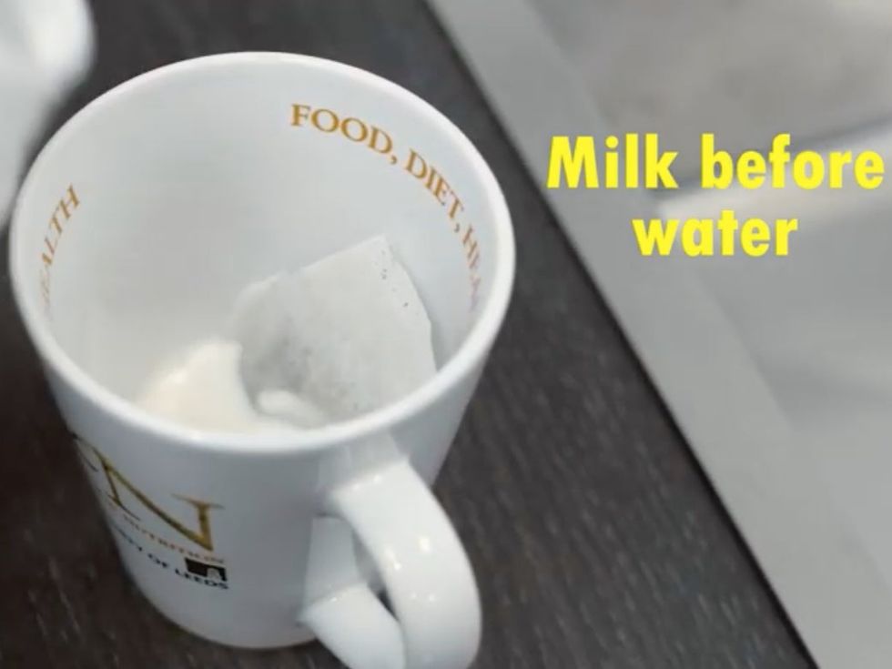 Milk being poured over tea bag