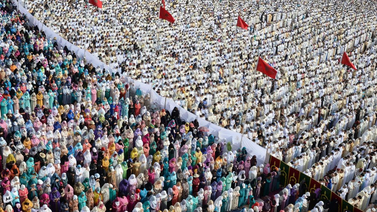 Moroccan Muslim women (L) and men (R) perform prayers for Eid al-Fitr which marks the end of the Muslim holy fasting month of Ramadan in the city of Sale, north of the Moroccan capital Rabat, on July 18, 2015.