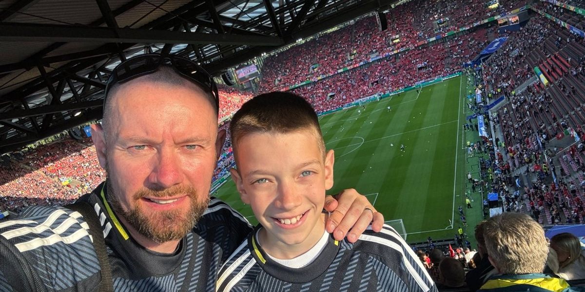 Vater und Sohn schauen sich das Schottland-Spiel in Deutschland an und hoffen, dass die Mannschaft gewinnt Vater und Sohn schauen sich das Schottland-Spiel in Deutschland an und hoffen, dass die Mannschaft gewinnt