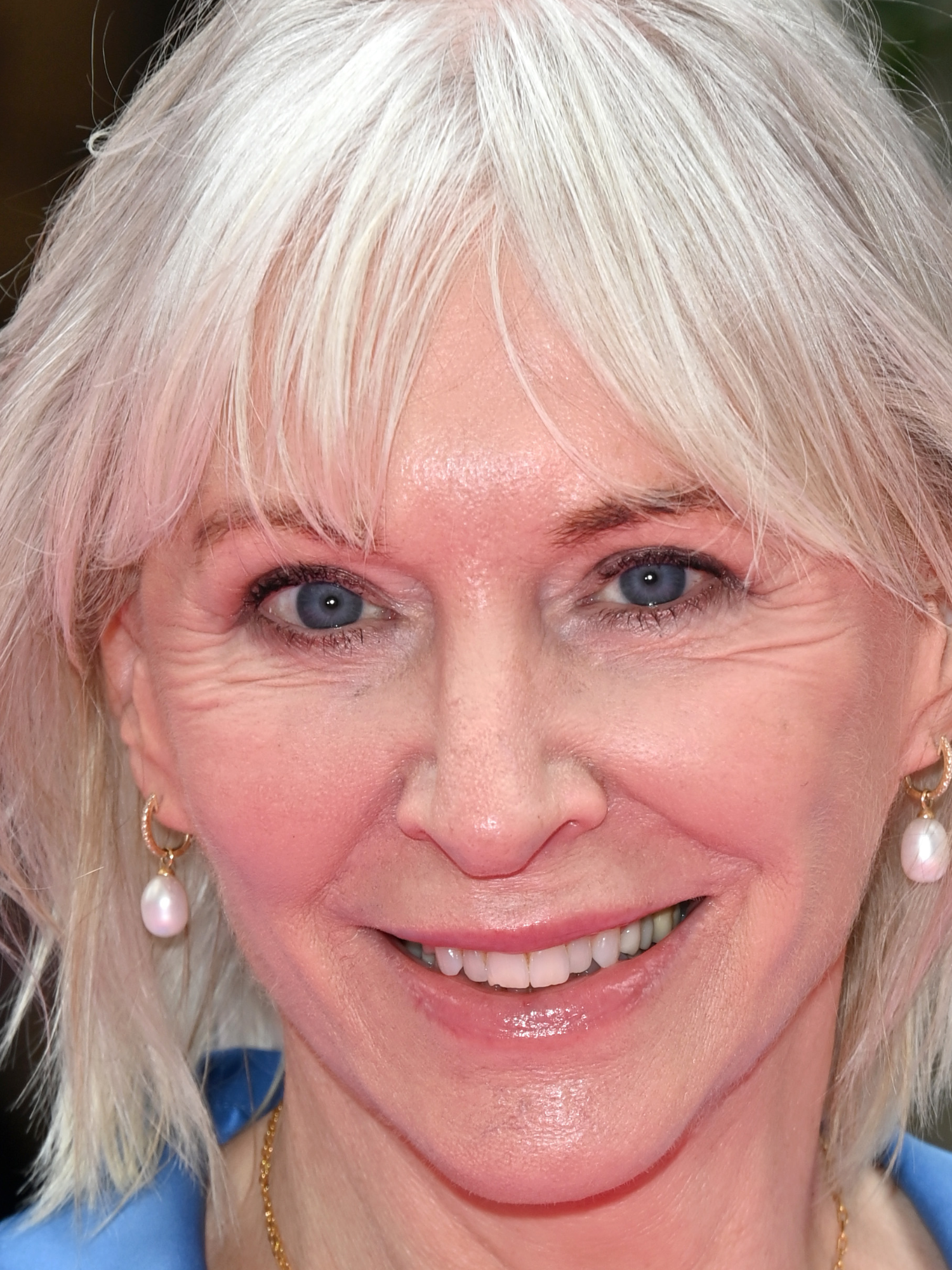 Nadine Dorries, a white woman with white hair, smiles at the camera.