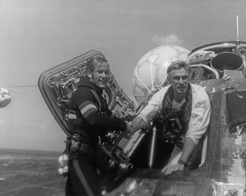 NASA astronaut Eugene Cernan, Commander of the Apollo 17 lunar mission, is welcomed back to Earth by a US Navy Pararescueman, after splashdown in the Pacific Ocean, 19 December 1972.