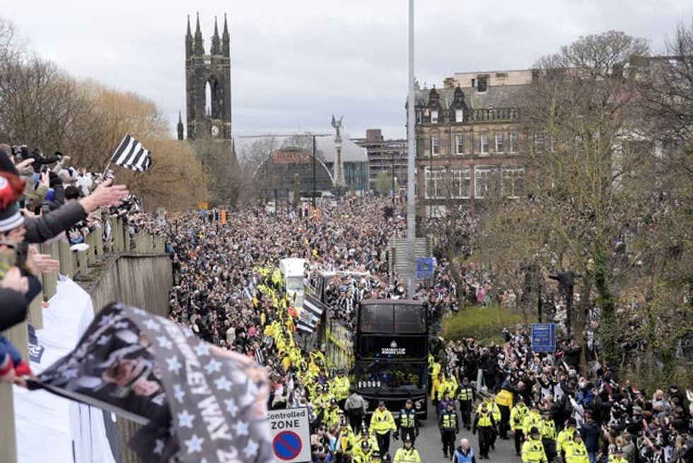 Newcastle United fans watch on as the players pass by aboard an open top bus during the Carabao Cup trophy parade in Newcastle