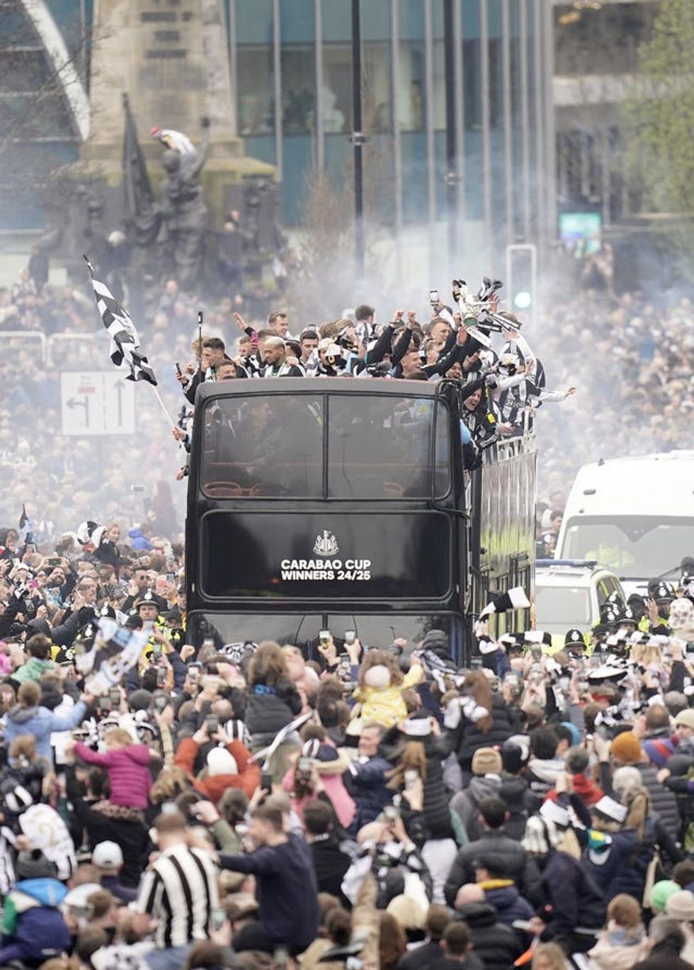 Newcastle United fans watch on as the players pass by aboard an open top bus during the Carabao Cup trophy parade in Newcastle