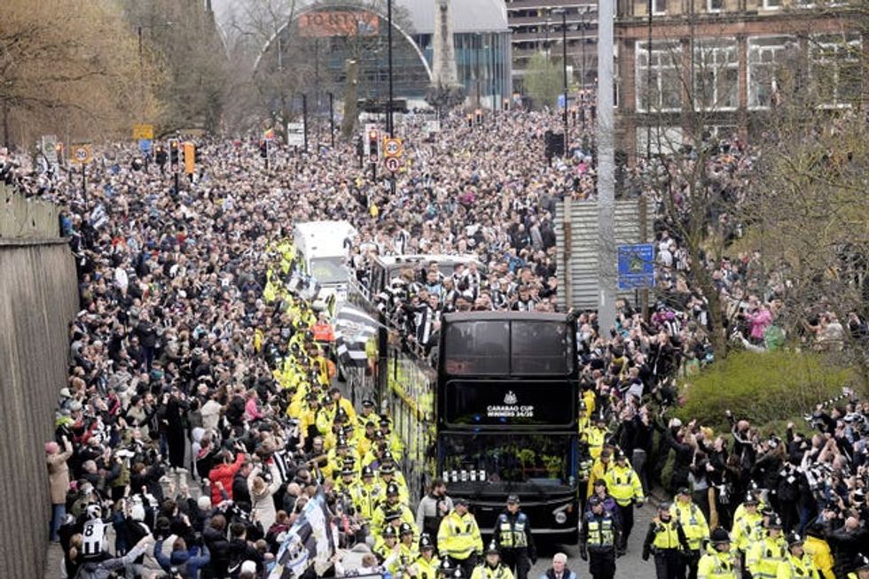 Newcastle United fans watch on as the players pass by aboard an open top bus during the Carabao Cup trophy parade in Newcastle.