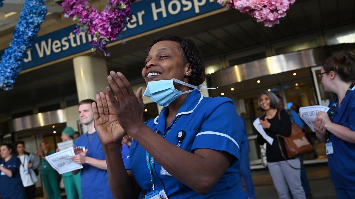<p> NHS workers participate in a national ‘clap for carers’ in May 2020</p>
