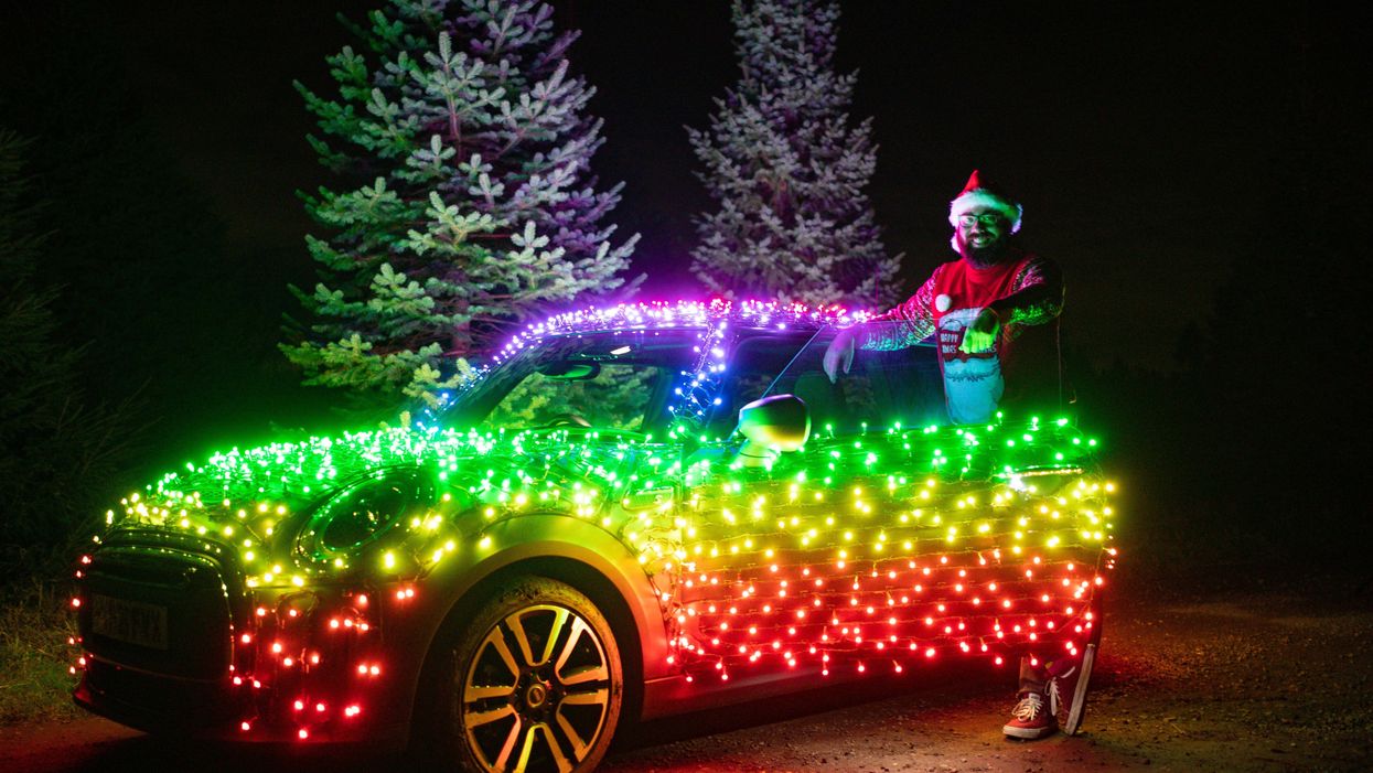 Nico Martin with a Mini Electric wrapped in thousands of Christmas fairy lights (Jacob King/PA)