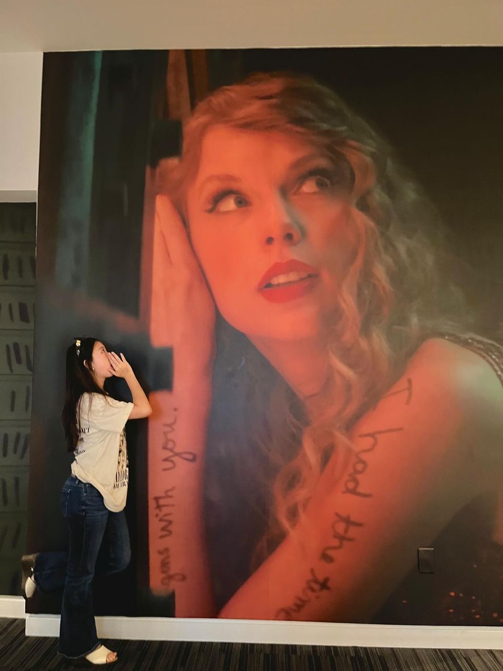 Nicole standing underneath a large photo of Taylor Swift