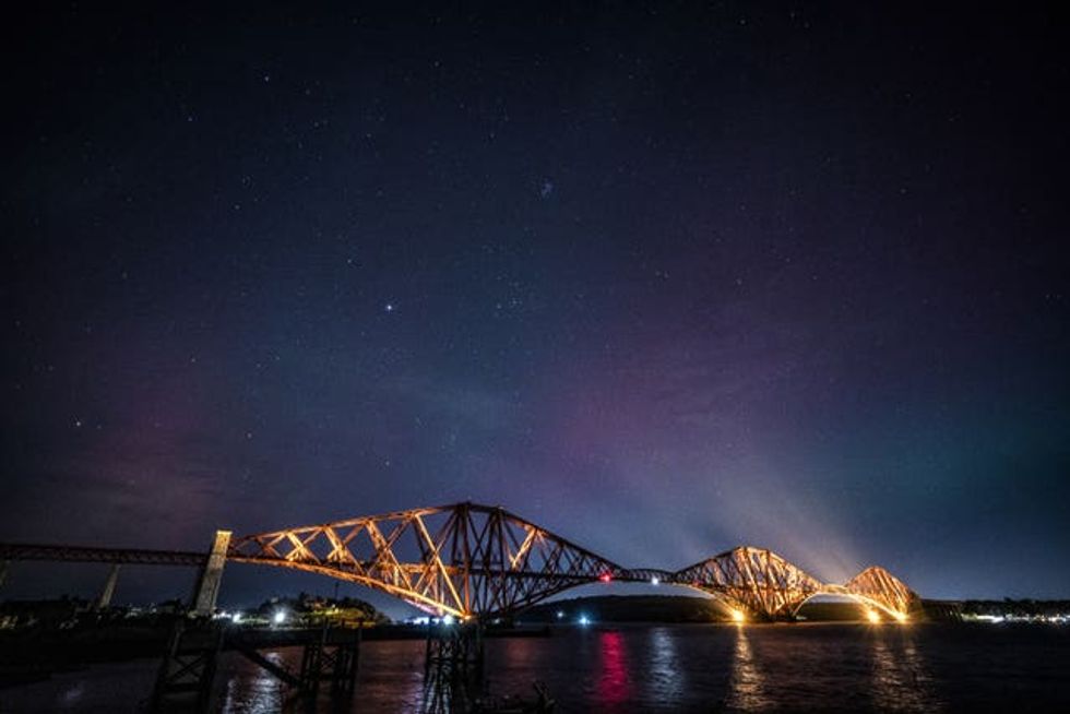 Northern Lights light up above the Forth Bridge, North Queensferry in Fife