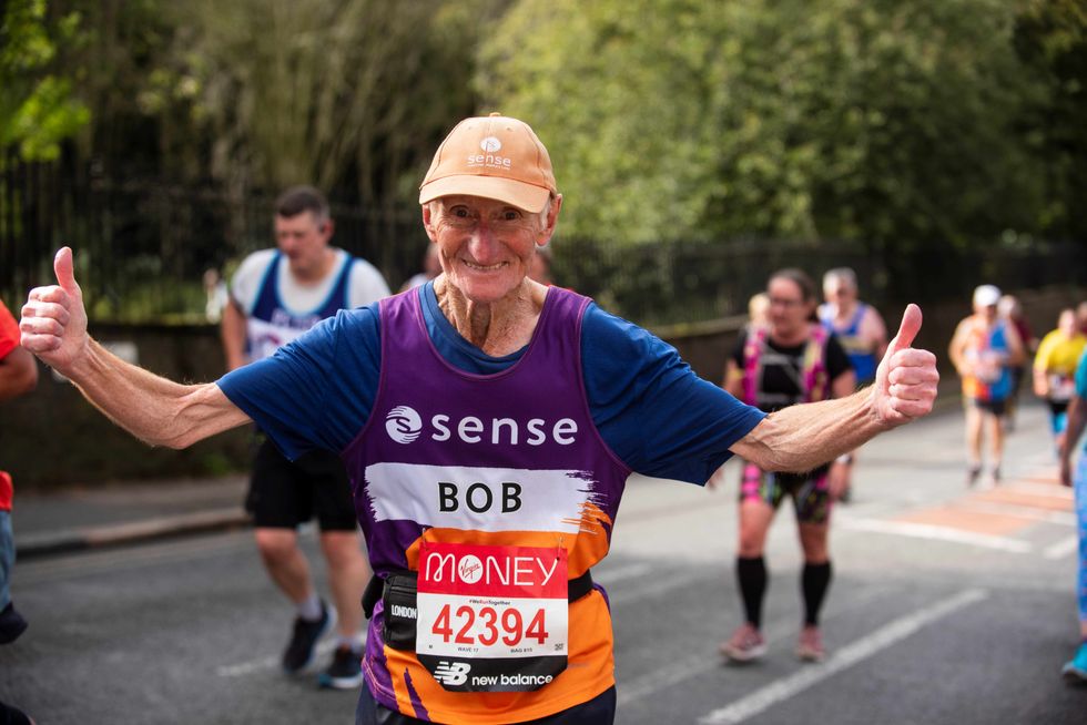 Octogenarian named Bob Smith with his arms outstretched and smiling as he runs the London Marathon