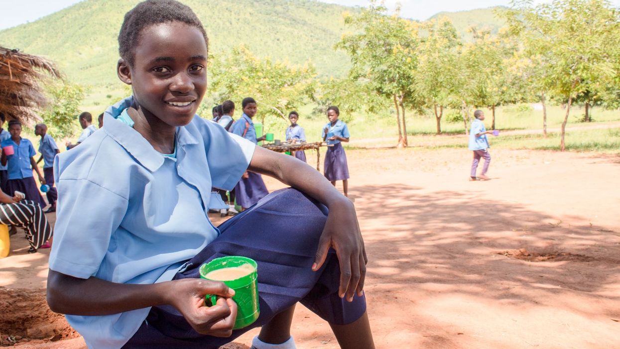 Olivia from Zambia receives a mug of Mary’s Meals porridge each day which helps her concentrate at school (PA)
