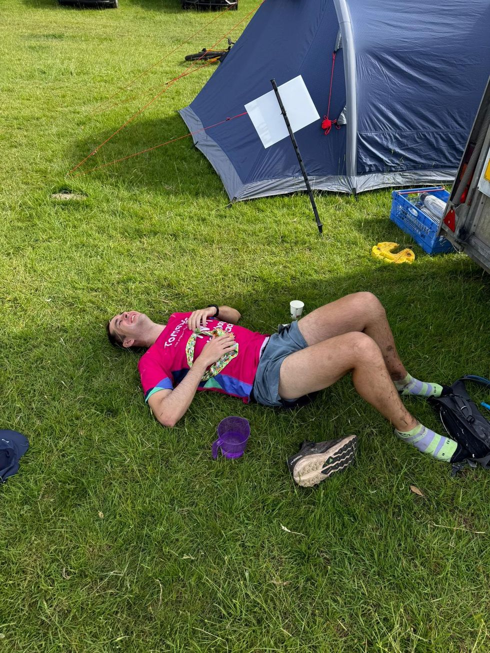 Olly Brown lying on the ground near a tent