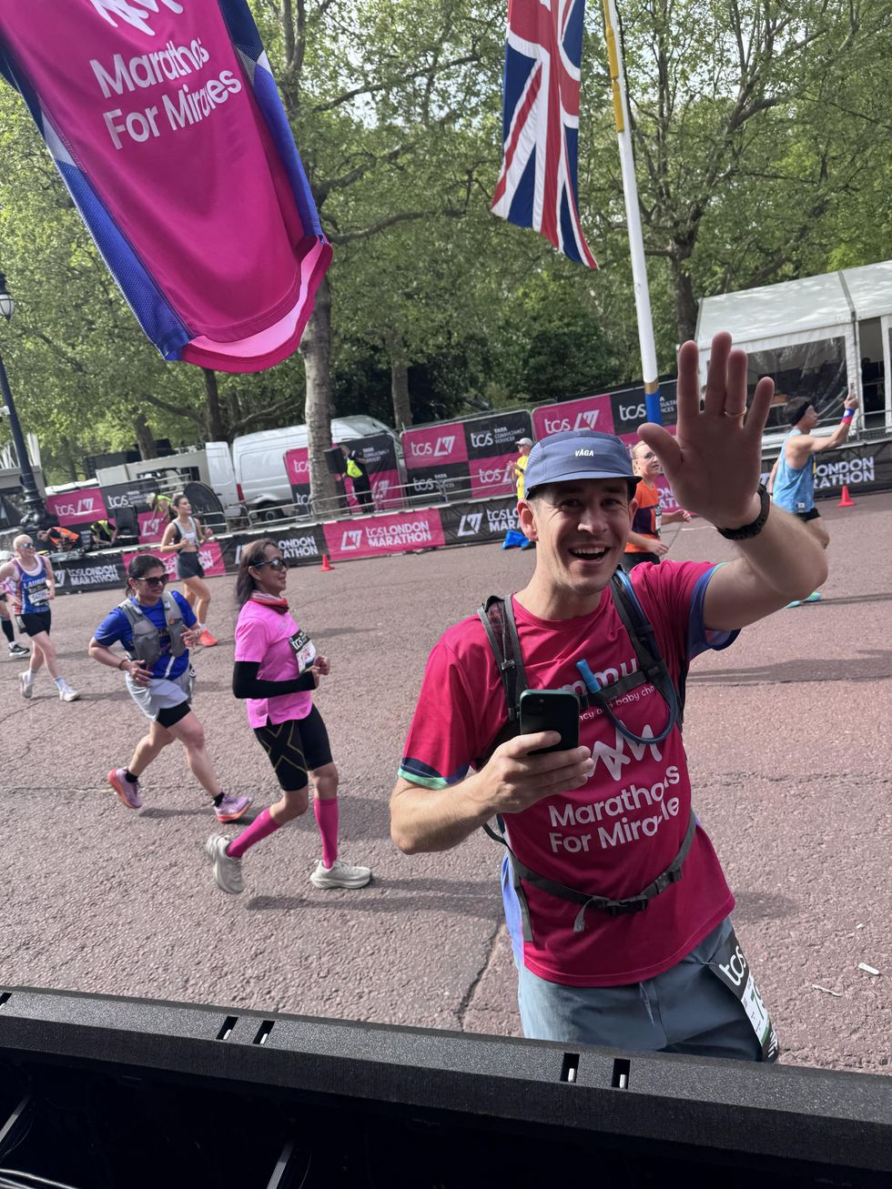 Olly Brown waves after pausing during a marathon