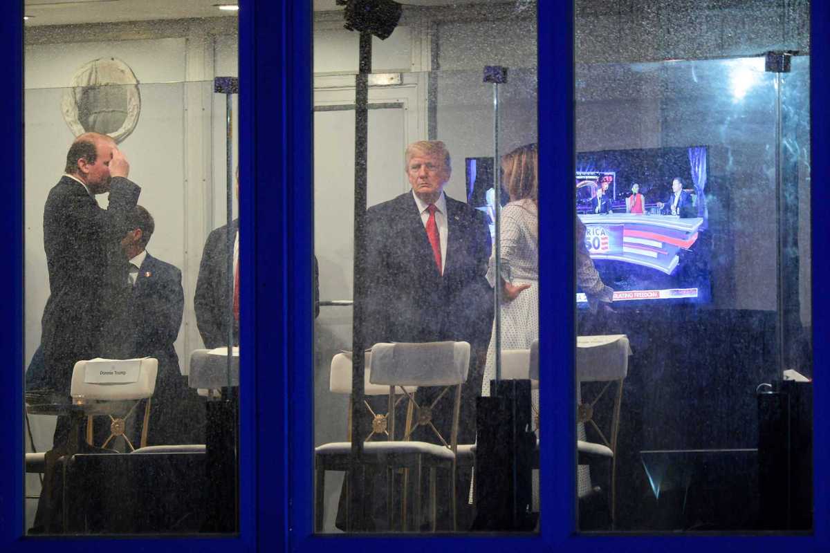 Outside photo of US president Donald Trump in a room with staff, with Fox News on the television behind them.