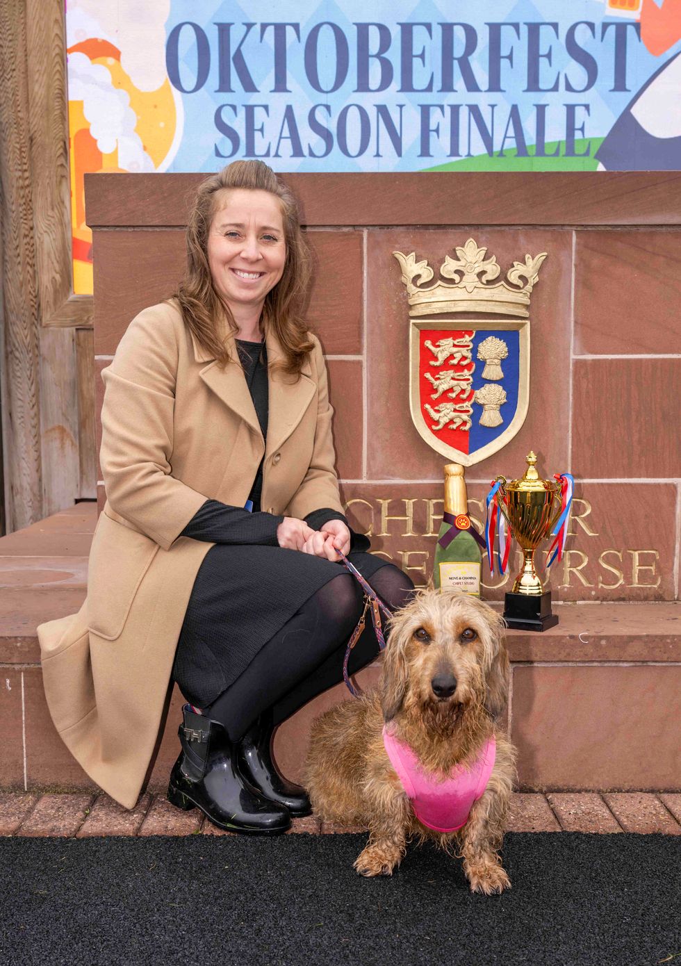 Owner Melanie Ashley next to the winner's trophy and Champagne bottle with Nellie, a five-year-old standard wirehaired dachshund, who won the first ever Dachshund Derby at Chester Racecourse