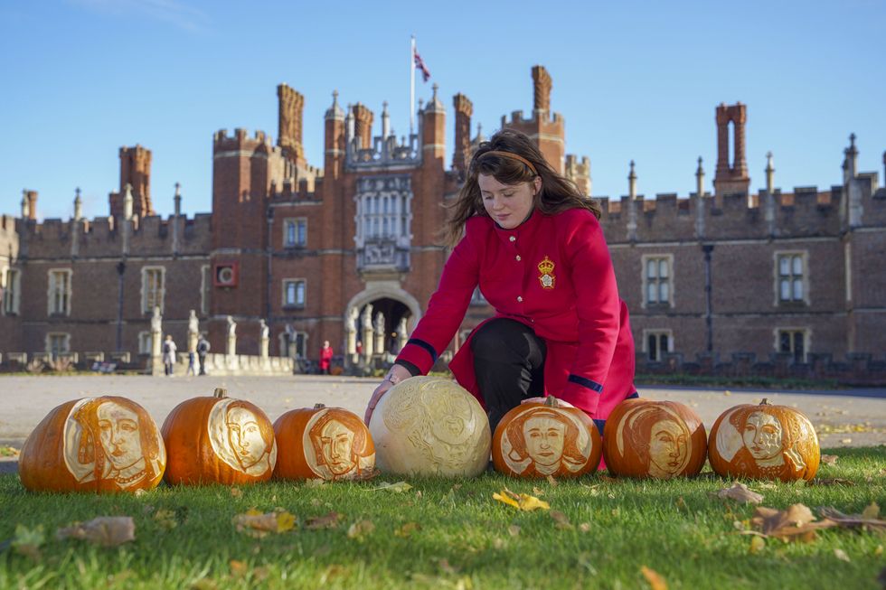 Palace host Aurora Heimsath with pumpkins bearing the face of Henry VIII and his wives (Steve Parsons/PA)