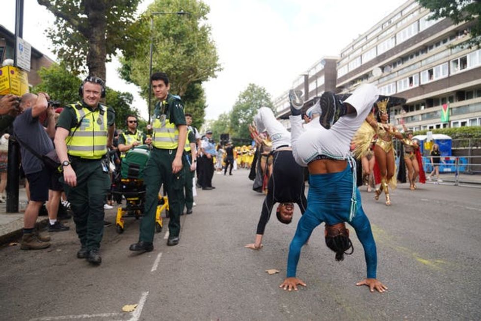 Paramedics (left) pass by acrobatic participants