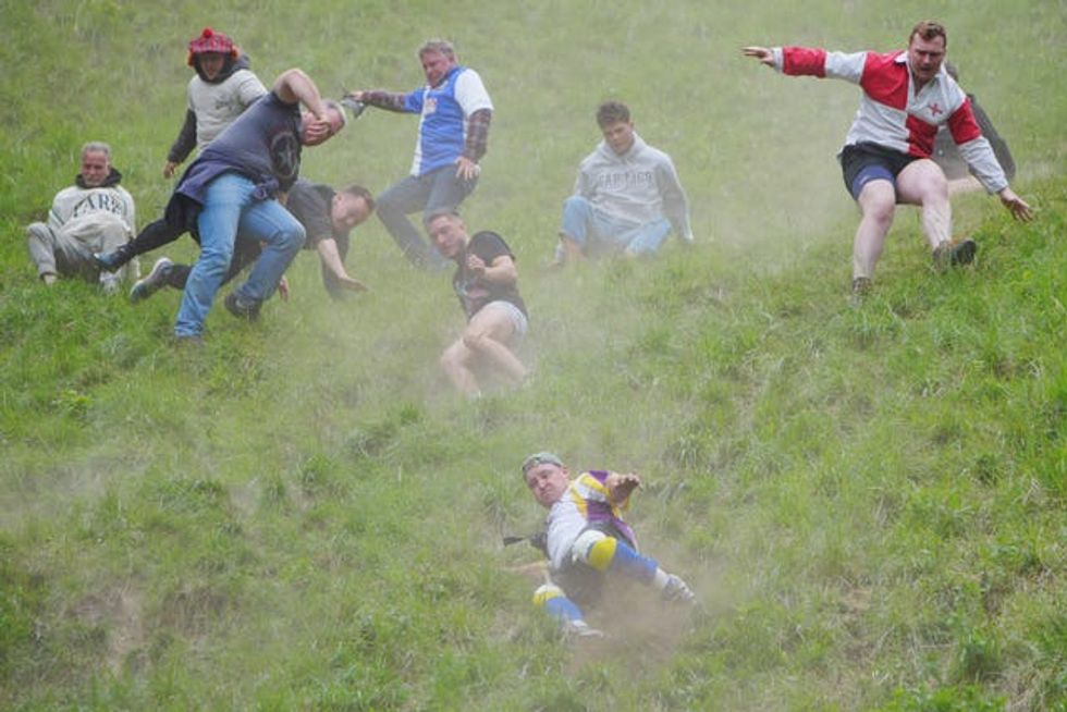 Participants take part in the annual cheese rolling at Cooper\u2019s Hill in Brockworth, Gloucestershire