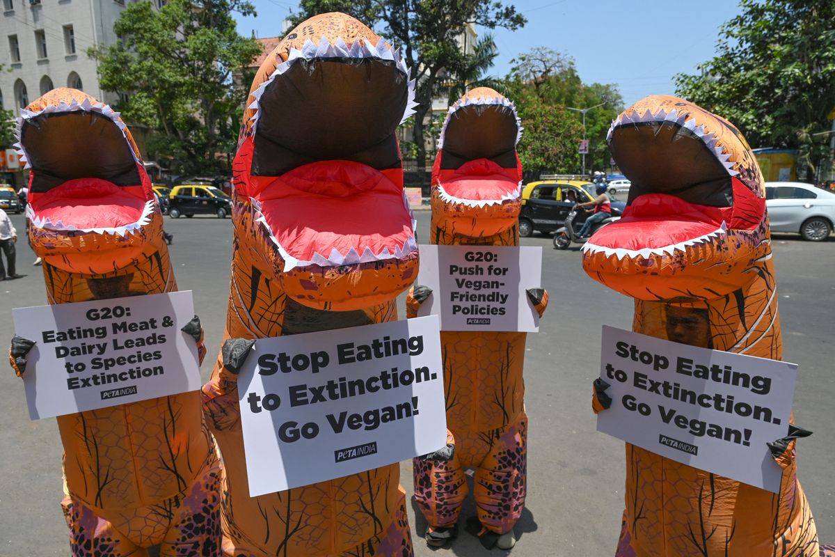 People dressed as dinosaurs protest for veganism in India