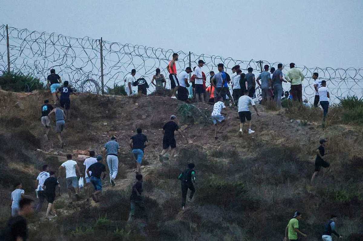 People gather on a hilltop near Bab Sebta on the Morocco-Spain border, near Spain's enclave of Ceuta and the Moroccan town of Fnideq.