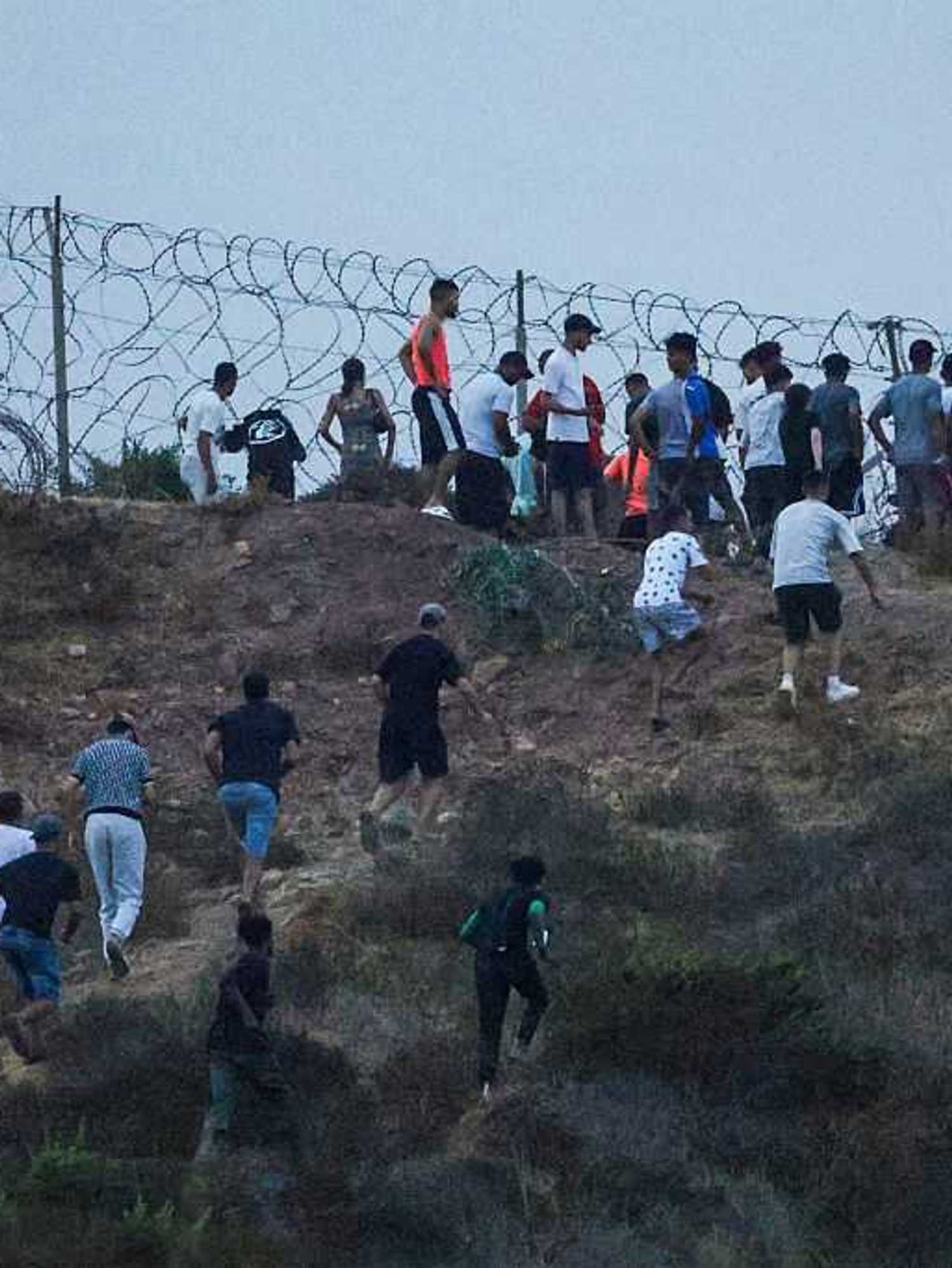 People gather on a hilltop near Bab Sebta on the Morocco-Spain border, near Spain's enclave of Ceuta and the Moroccan town of Fnideq.