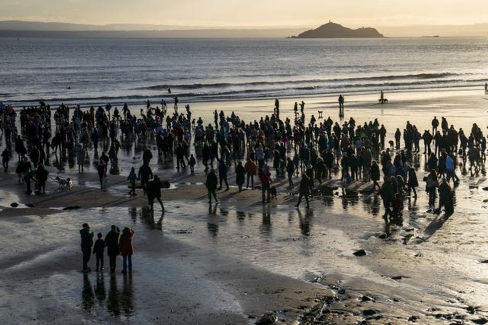 People gather on the beach to watch the Loony Dook New Year\u2019s Day dip in the Firth of Forth at Kinghorn