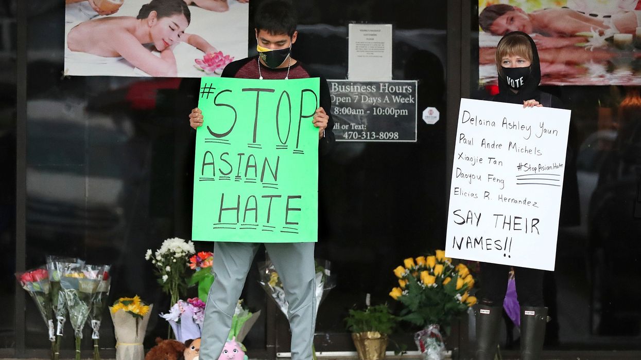 <p>People hold placards in support of the Asian and Hispanic community outside Young's Asian Massage in Acworth, Georgia </p>