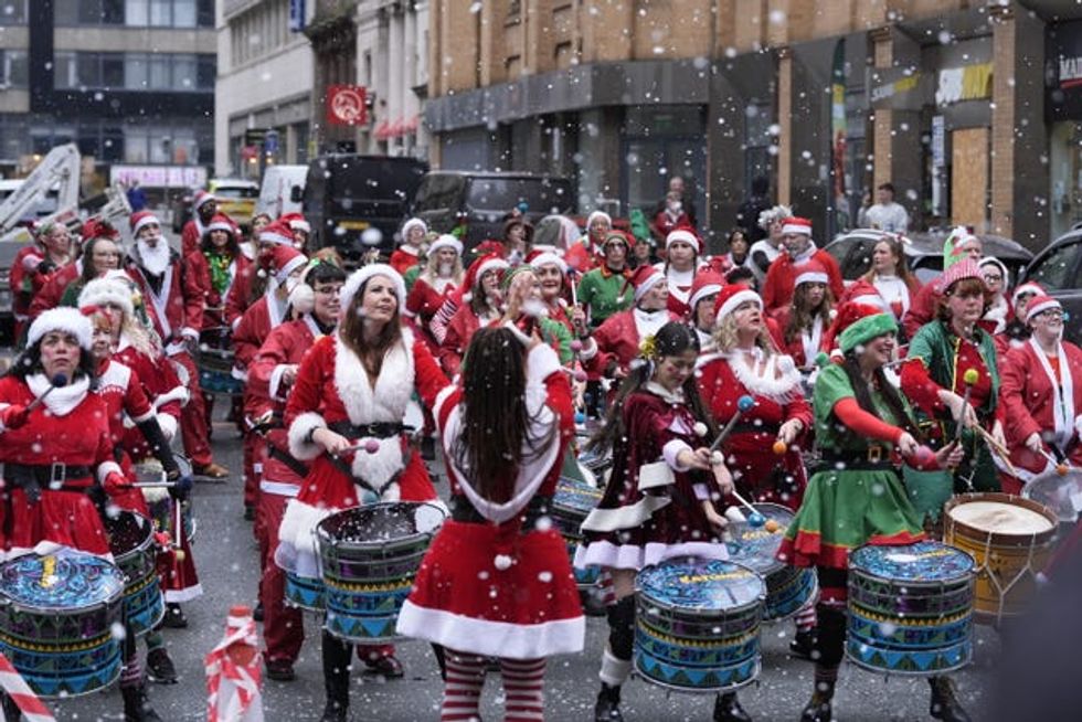 People in Santa suits play steel drums