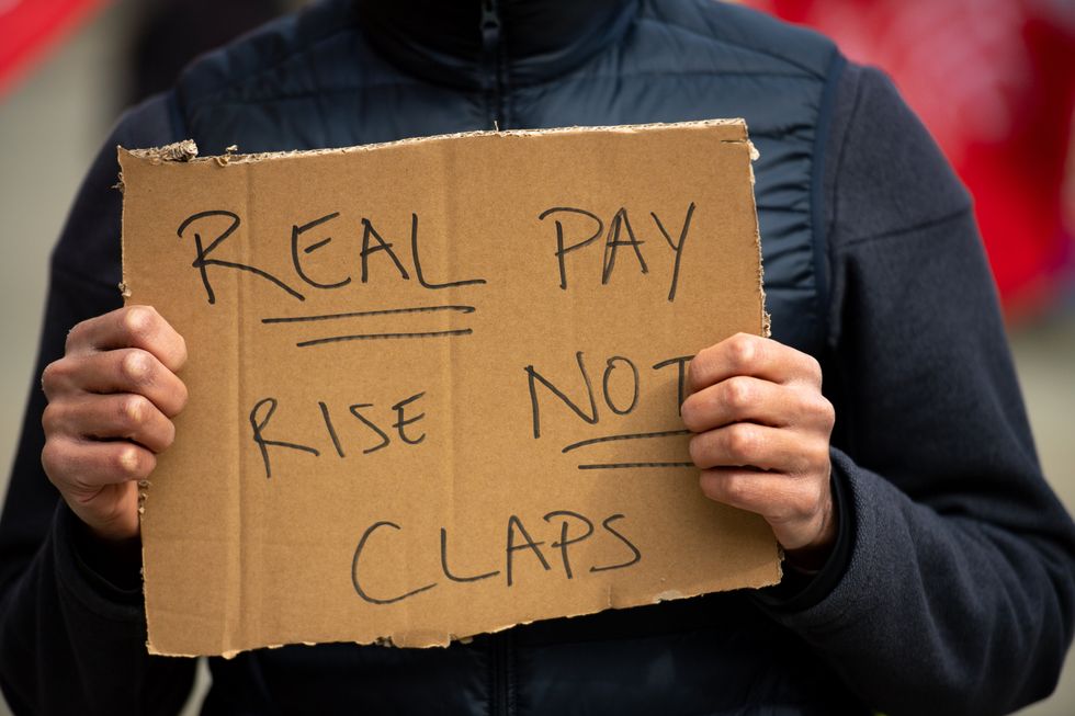 People protesting in St Peter\u2019s Square in Manchester, over the proposed 1% pay rise for NHS workers (Jacob King/PA)
