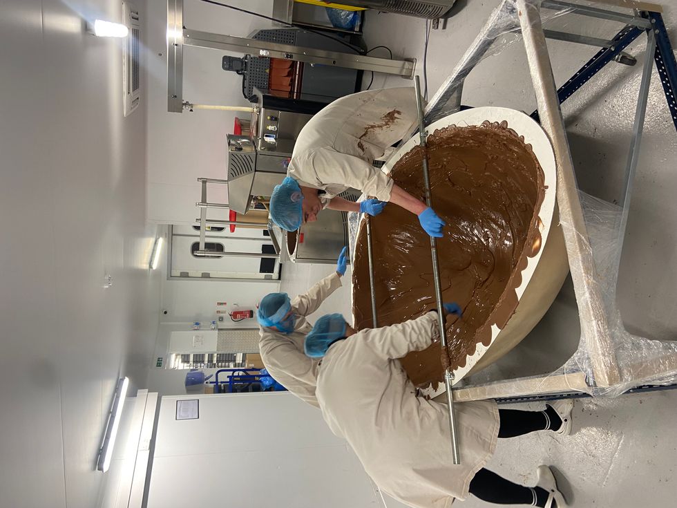 People putting their hands inside a chocolate egg