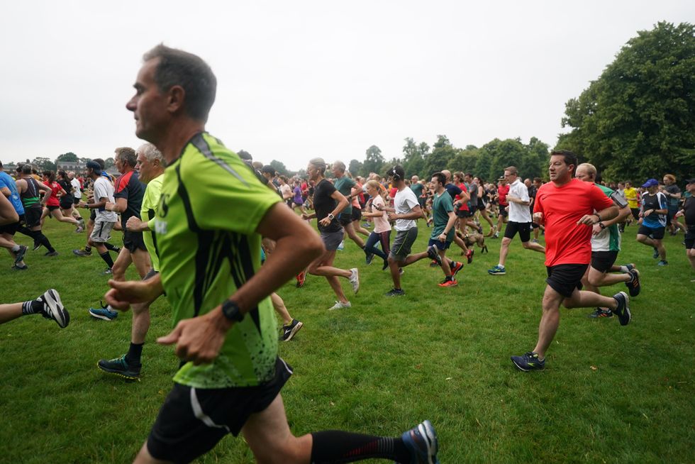 People take part in the Parkrun at Bushy Park in London, one of many runs taking place across the country for the first time since last March (Victoria Jones/PA)