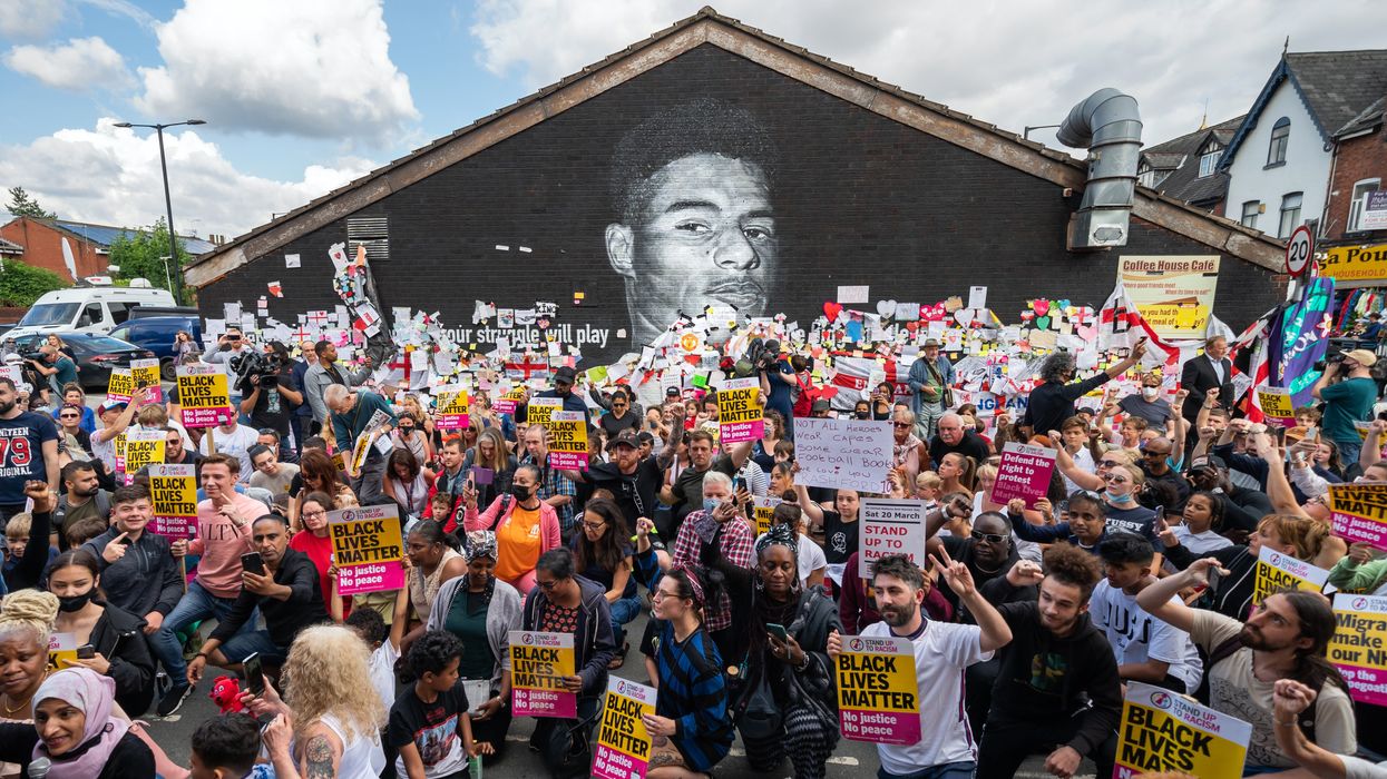 <p>People take the knee at the mural </p>