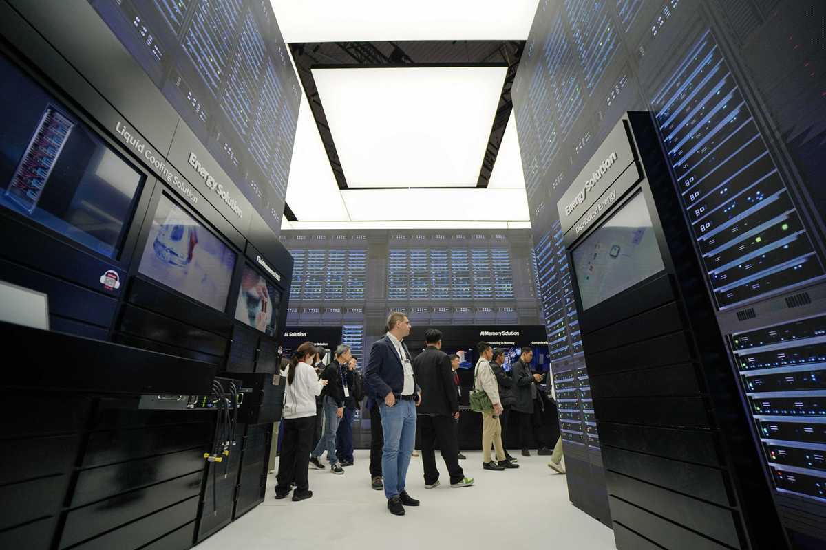 People walk around an AI data centre at a conference.