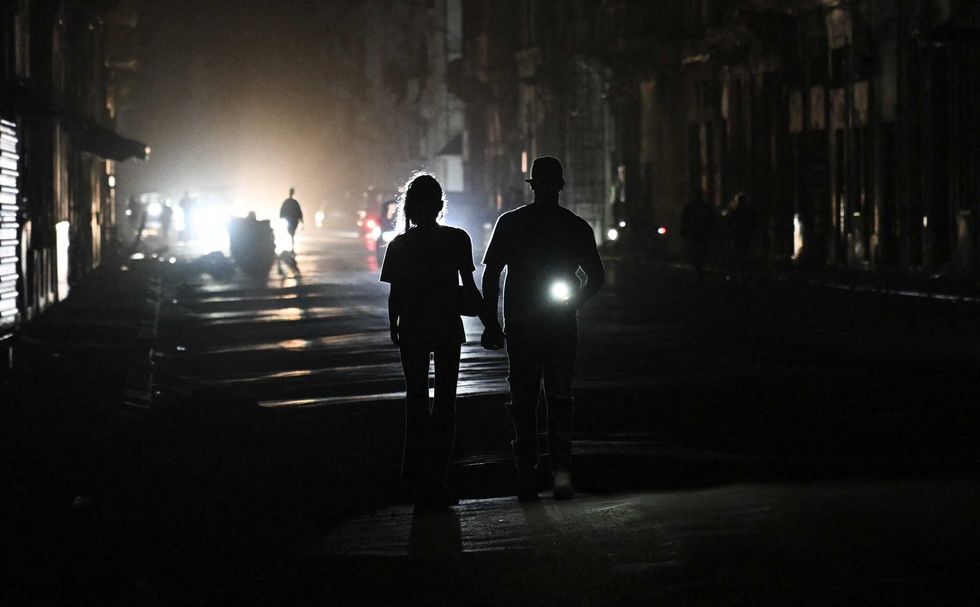 People walk on a street without power during a nation wide blackout in Havana on March 21, 2026