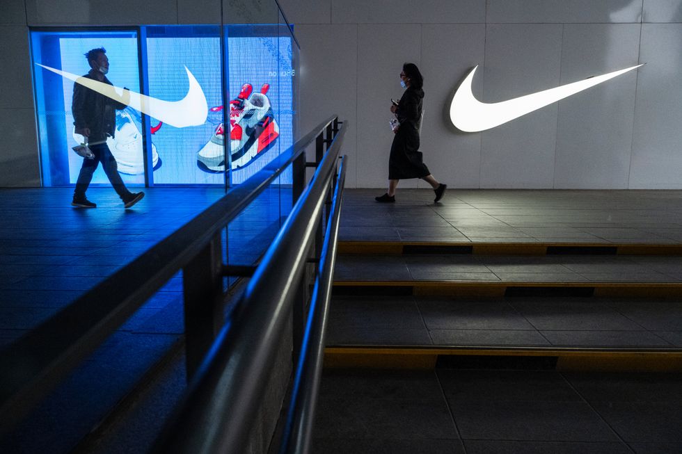 People walk outside a Nike store at a shopping area on April 8, 2021 in Beijing, China