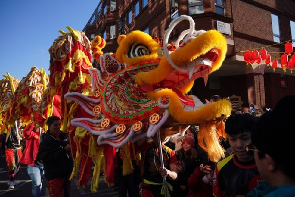Performers hold up a yellow display during the parade