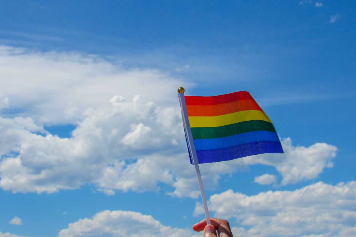 person holding flag of america under white clouds and blue sky during daytime