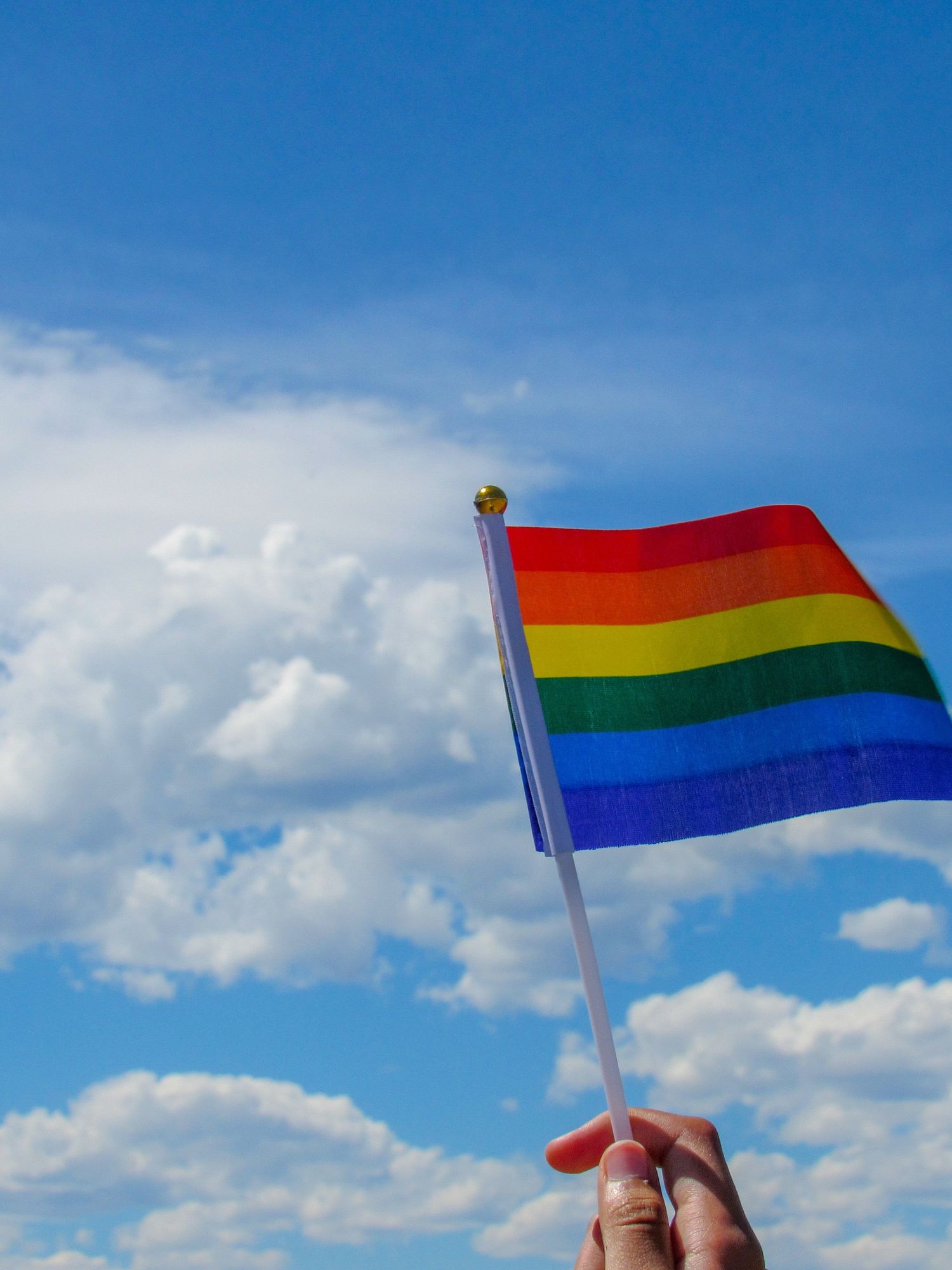 person holding flag of america under white clouds and blue sky during daytime