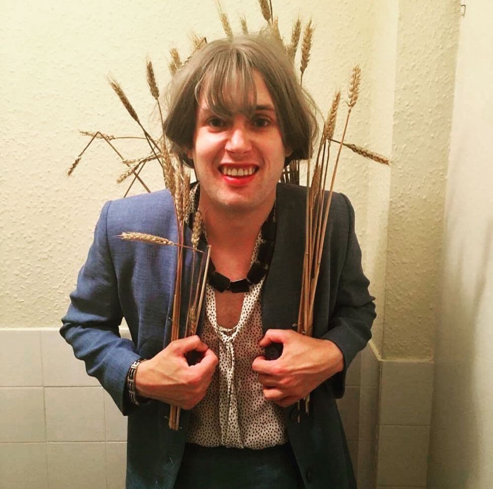 Person holding wheat and looking at the camera