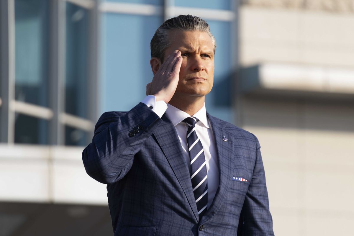 Pete Hegseth in a blue suit and tie, saluting.