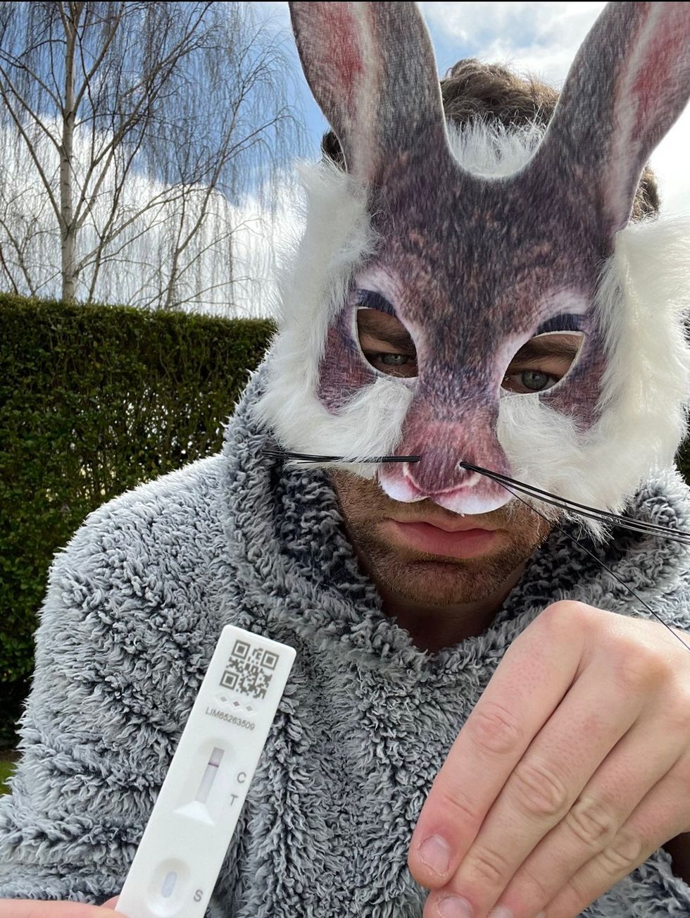 Philip Joel poses in a rabbit costume with his Covid test