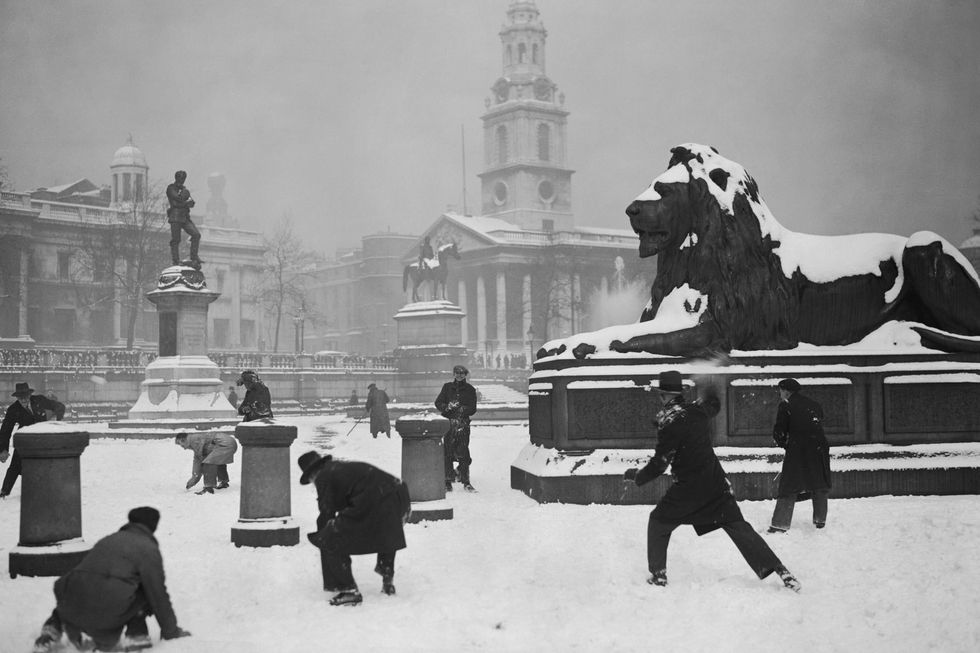 Picture: A group of men have a snowball fight in a snow-covered Trafalgar Square in London