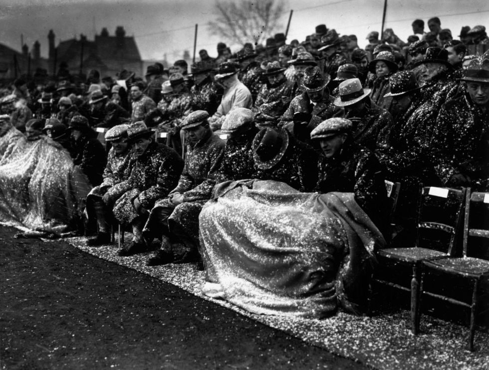 Picture: A group of spectators watch a Cambridge University Athletics meeting in the snow at Fenners Athletic Ground
