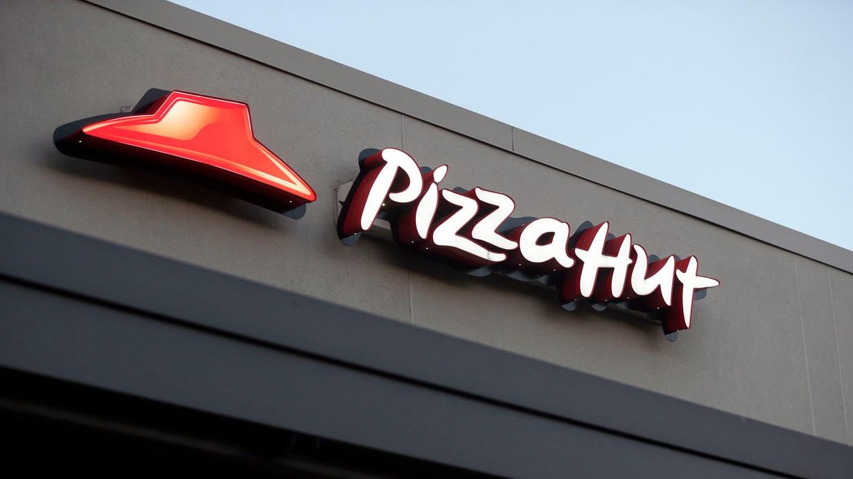 Pizza Hut server appears to eat soup from ladle at buffet counter