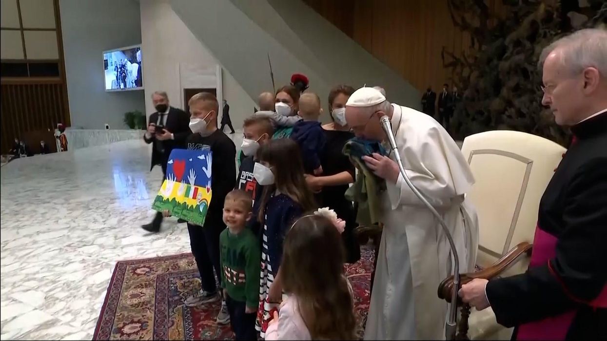 Pope Francis kisses Ukrainian flag brought to him from Bucha