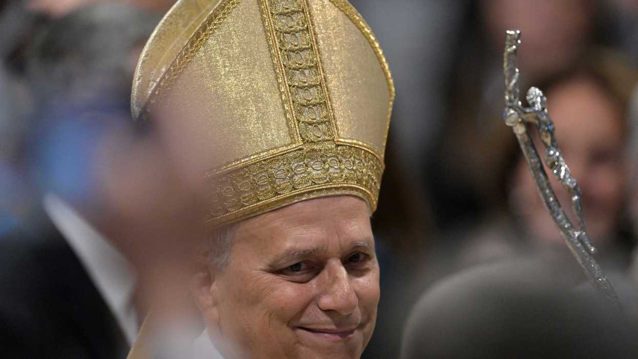 Pope Leo smiling and wearing a golden skullcap.