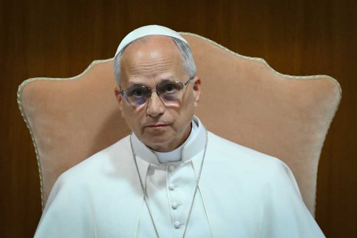 Pope Leo XIV, in his white religious clothing, sitting in a cream chair.