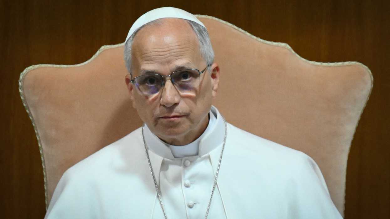 Pope Leo XIV, in his white religious clothing, sitting in a cream chair.