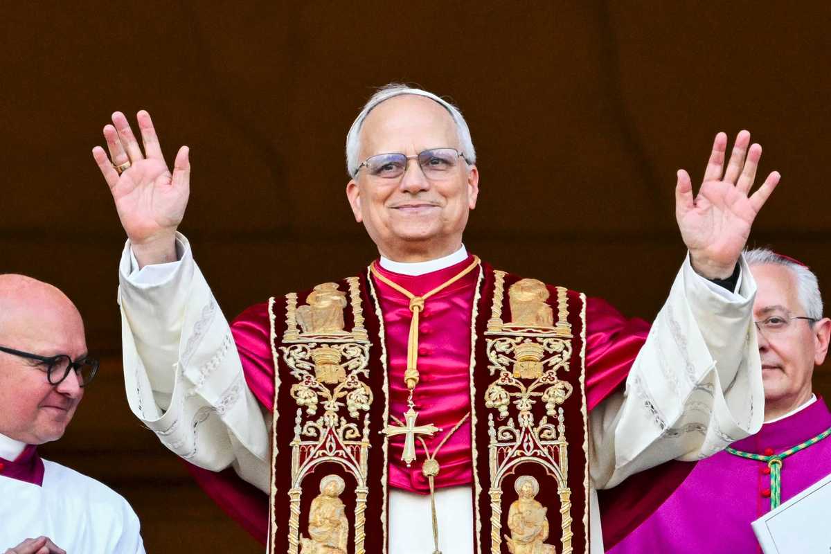 Pope Lo raises his hands and smiles on the main central loggia balcony of the St Peter's Basilica.