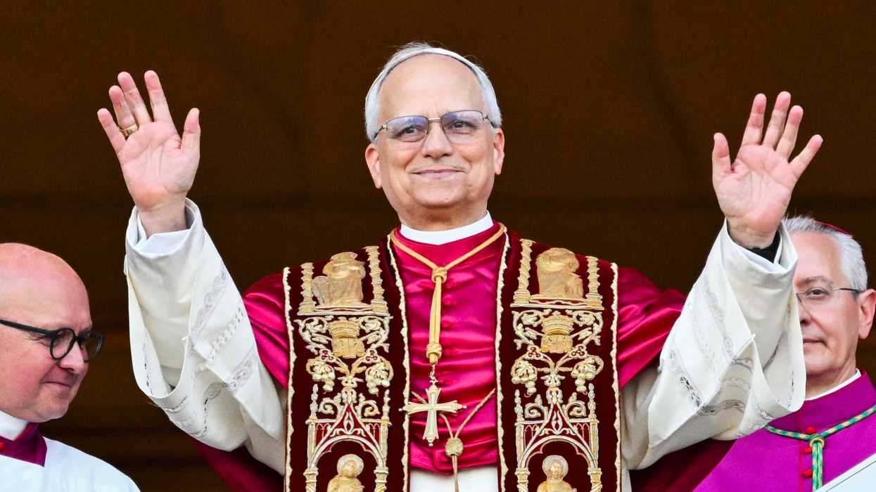 Pope Lo raises his hands and smiles on the main central loggia balcony of the St Peter's Basilica.
