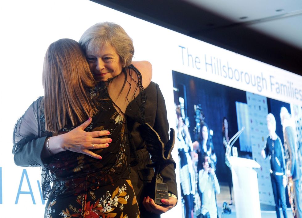 Prime Minister Theresa May congratulates Margaret Aspinall, who won the Special Award on behalf of the Hillsborough families, on stage at the 2016 Women of the Year Lunch & Awards, at the InterContinental London Park Lane, London.